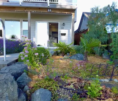 a garden in front of a house with flowers at AnnArthur Guest House in Nanaimo