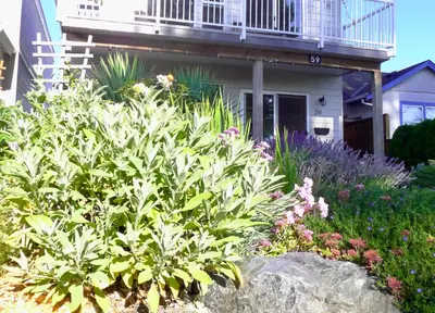 a garden in front of a house with flowers at AnnArthur Guest House in Nanaimo