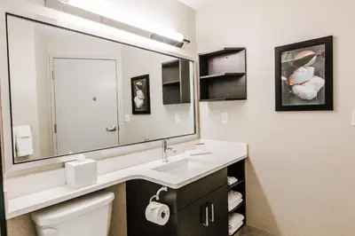 a bathroom with a sink and a large mirror at Candlewood Suites West Edmonton - Mall Area by IHG in Edmonton