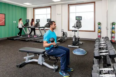 a man sitting on a chair in a gym at Candlewood Suites West Edmonton - Mall Area by IHG in Edmonton