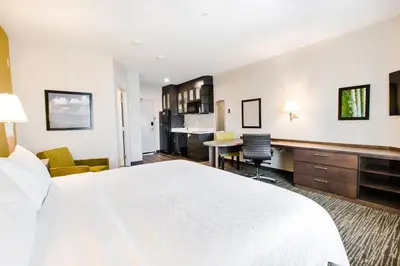 a hotel room with a large bed and a kitchen at Candlewood Suites West Edmonton - Mall Area by IHG in Edmonton