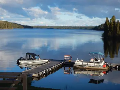 two boats are docked at a dock on a lake at Nimpo Lake Resort in Nimpo Lake