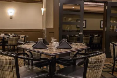 a dining room with a table and chairs at Chateau Nova Peace River in Peace River