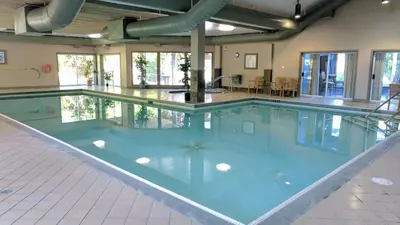 a large swimming pool with blue water in a building at Pacific Shores Resort & Spa in Nanoose Bay