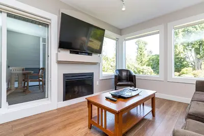 a living room with a fireplace and a tv at Pacific Shores Resort & Spa in Nanoose Bay