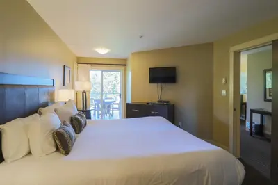 a bedroom with a large white bed with pillows at Pacific Shores Resort & Spa in Nanoose Bay