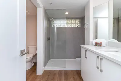 a white bathroom with a shower and a toilet at Pacific Shores Resort & Spa in Nanoose Bay