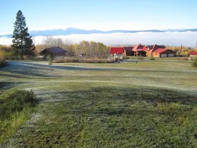 an empty field with houses in the background at Smithers Driftwood Lodge in Smithers