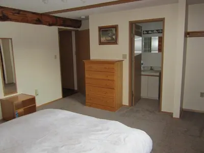 a bedroom with a bed and a wooden dresser at Smithers Driftwood Lodge in Smithers