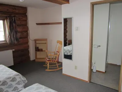 a bedroom with a bed and a table and a chair at Smithers Driftwood Lodge in Smithers