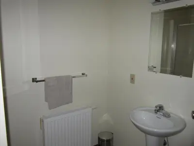 a white bathroom with a sink and a mirror at Smithers Driftwood Lodge in Smithers
