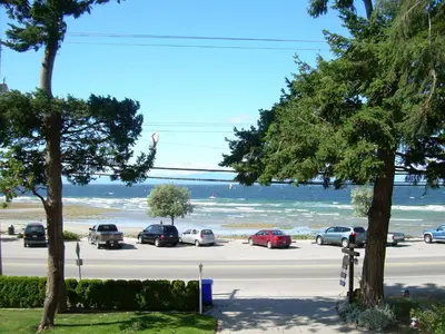a parking lot with cars parked next to the beach at Davis Bay Bed & Breakfast in Sechelt