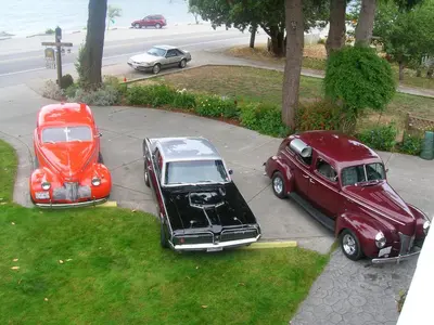 three antique cars parked on a sidewalk in a street at Davis Bay Bed & Breakfast in Sechelt