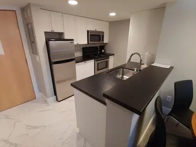 a kitchen with a sink and a refrigerator at Tyndalstone Lodge 3 Bedroom in the Heart of Village North Whistler in Whistler