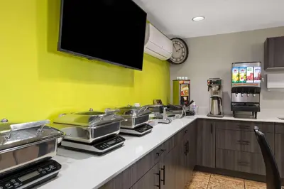 a kitchen with a counter with a tv on the wall at Super 8 by Wyndham Fort McMurray in Fort McMurray