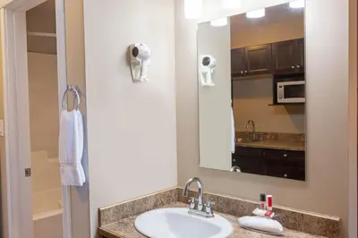 a bathroom with a sink and a mirror at Super 8 by Wyndham Fort McMurray in Fort McMurray