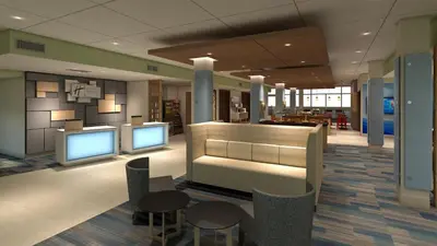a lobby with two monitors and tables and chairs at Holiday Inn Express & Suites Terrace by IHG in Terrace