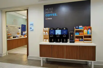 a coffee shop with a counter with bottles of coffee at Holiday Inn Express & Suites Terrace by IHG in Terrace