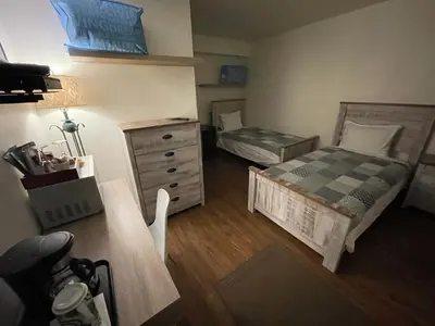 a small bedroom with two beds and a dresser at Sunset Motel in Cache Creek