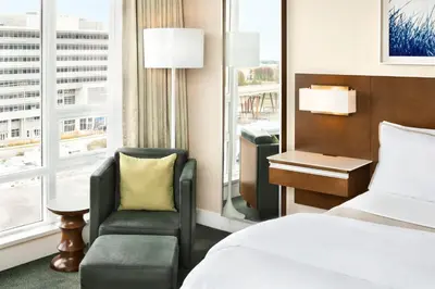 a hotel room with a bed and a chair and a window at The Westin Wall Centre, Vancouver Airport in Richmond