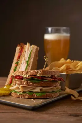 a sandwich on a plate next to a glass of beer at Hyatt Place Edmonton West in Edmonton