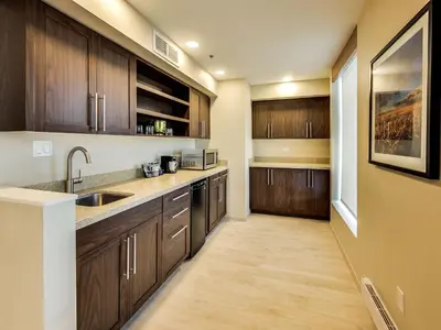 a kitchen with wooden cabinets and a sink at Hyatt Place Edmonton West in Edmonton