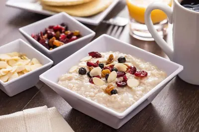 a bowl of oatmeal with fruit and nuts on a table at Hyatt Place Edmonton West in Edmonton