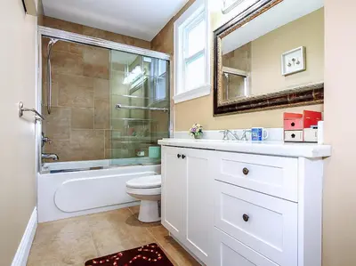 a bathroom with a sink and a toilet and a mirror at Vancouver Luxury Homestay in Richmond