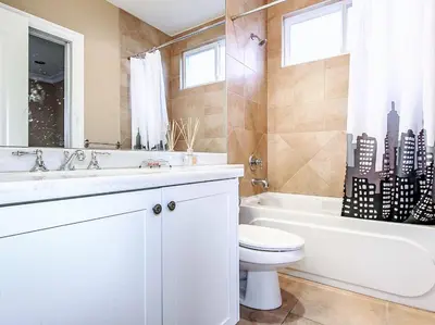 a white bathroom with a toilet and a tub and a sink at Vancouver Luxury Homestay in Richmond