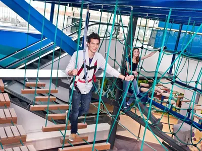 a man and a woman climbing up a ladder on an indoor climbing gym at West Edmonton Mall Inn in Edmonton