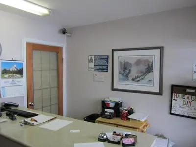 an office cubicle with a desk and a phone at Kacee's Northern Suites in Fort Nelson