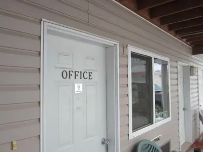 an office sign on the door of a house at Kacee's Northern Suites in Fort Nelson