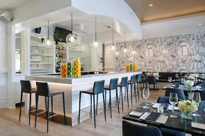 a restaurant with a bar with chairs and tables at Watermark Beach Resort in Osoyoos