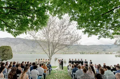 a wedding ceremony on the shore of a lake at Watermark Beach Resort in Osoyoos