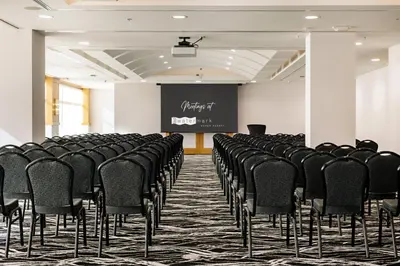 a conference room with black chairs and a screen at Watermark Beach Resort in Osoyoos