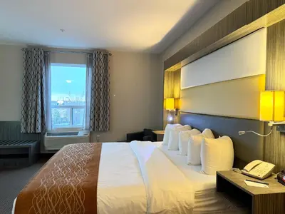 a hotel room with a bed and a phone at Southfort Inn in Fort Saskatchewan