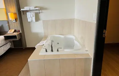 a bathroom with a bath tub in a hotel room at Southfort Inn in Fort Saskatchewan
