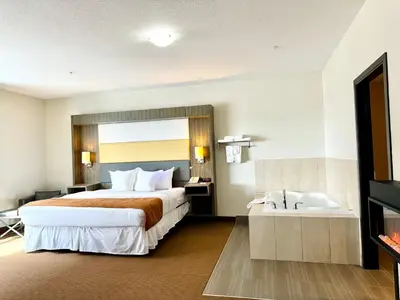 a hotel room with a bed and a bath tub at Southfort Inn in Fort Saskatchewan