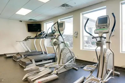a gym with treadmills and elliptical machines at Carriage House Hotel and Conference Centre in Calgary