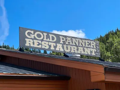 a sign for a gold panner restaurant on top of a building at Hotel Carmacks in Carmacks