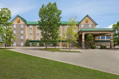 a large building with a green roof at Super 8 by Wyndham Calgary Shawnessy Area in Calgary