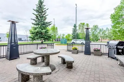 a park with benches and a grill and a picnic table at Super 8 by Wyndham Calgary Shawnessy Area in Calgary