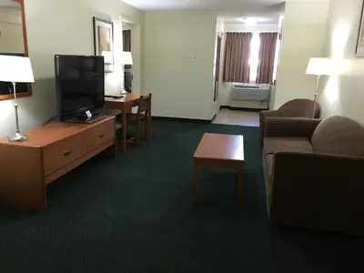 a living room with a couch and a tv in a hotel room at Western Valley Inn in Valleyview