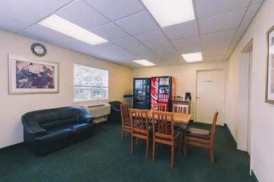 a waiting room with a table and chairs and a couch at Western Valley Inn in Valleyview