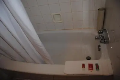 a bathroom with a bath tub with a shower curtain at Economy Inn in Edmonton
