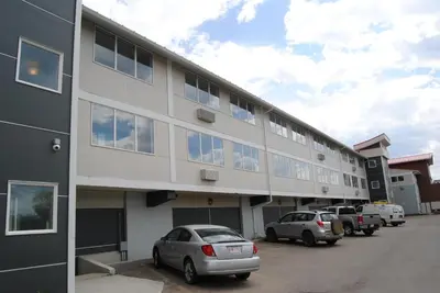 a building with cars parked in a parking lot at Economy Inn in Edmonton