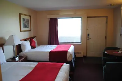 a hotel room with two beds and a window at Economy Inn in Edmonton