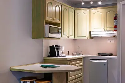 a kitchen with wooden cabinets and a counter top at Tiki Shores Inn & Suites in Penticton