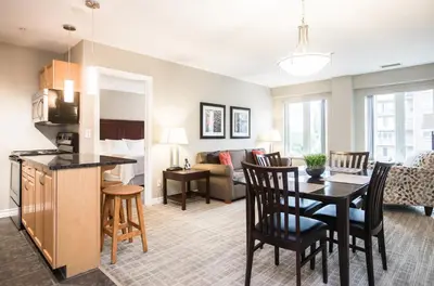 a living room with a kitchen and a dining room at Canterra Suites Hotel in Edmonton