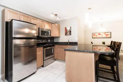 a kitchen with a stainless steel refrigerator at Canterra Suites Hotel in Edmonton